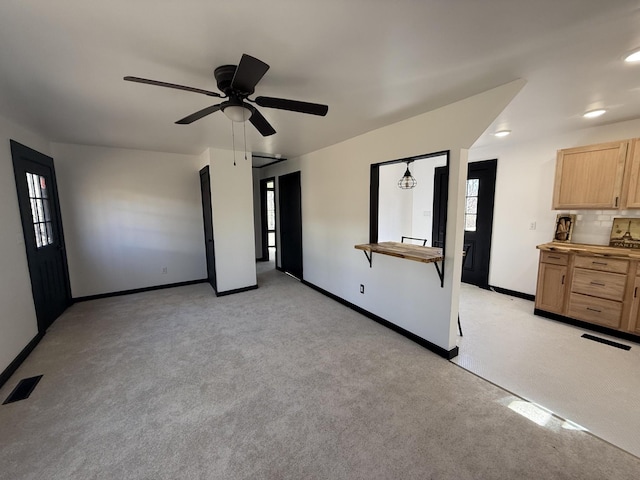 interior space with ceiling fan, baseboards, visible vents, and light carpet