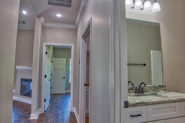 bathroom featuring visible vents, wood finished floors, baseboards, and ornamental molding