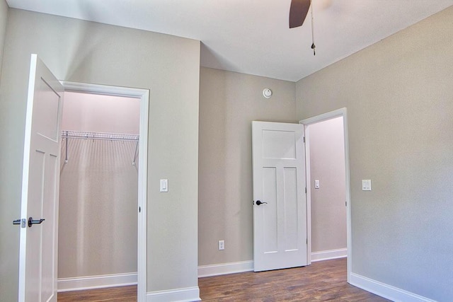 unfurnished bedroom featuring a closet, a ceiling fan, baseboards, and wood finished floors