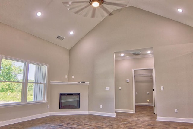 unfurnished living room with a glass covered fireplace, visible vents, dark wood-type flooring, and baseboards