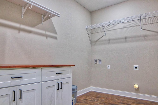 washroom with hookup for a washing machine, dark wood-style floors, baseboards, hookup for an electric dryer, and cabinet space