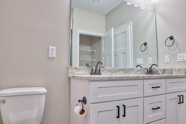 full bath featuring double vanity, visible vents, and toilet