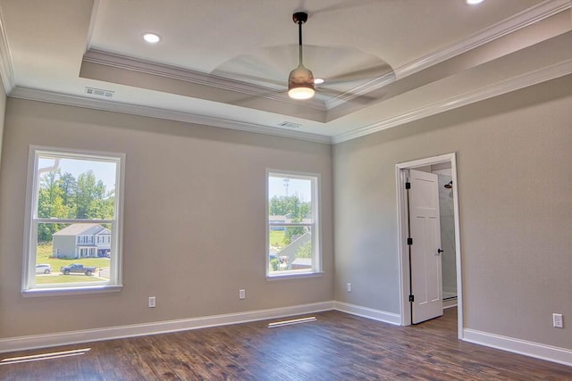 spare room with visible vents, a raised ceiling, ceiling fan, and wood finished floors