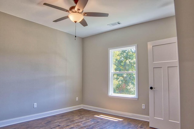 unfurnished room with visible vents, ceiling fan, dark wood-type flooring, and baseboards