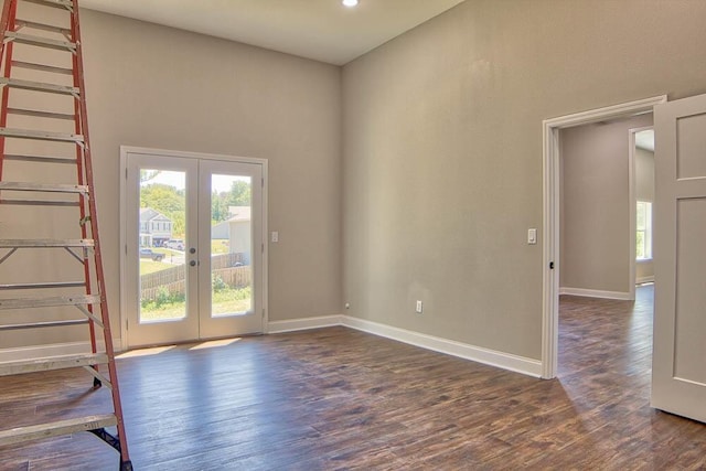 empty room featuring french doors, baseboards, and wood finished floors