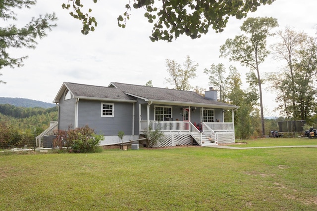 view of front of home with a front lawn, covered porch, and a chimney