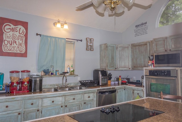 kitchen with a sink, vaulted ceiling, ceiling fan, and stainless steel appliances