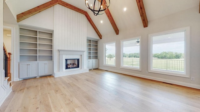 unfurnished living room with visible vents, stairway, beam ceiling, a fireplace, and wood finished floors