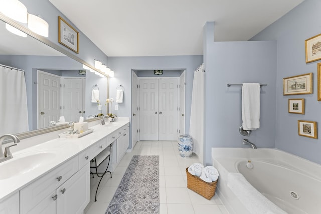 bathroom featuring tile patterned flooring, double vanity, a jetted tub, and a sink