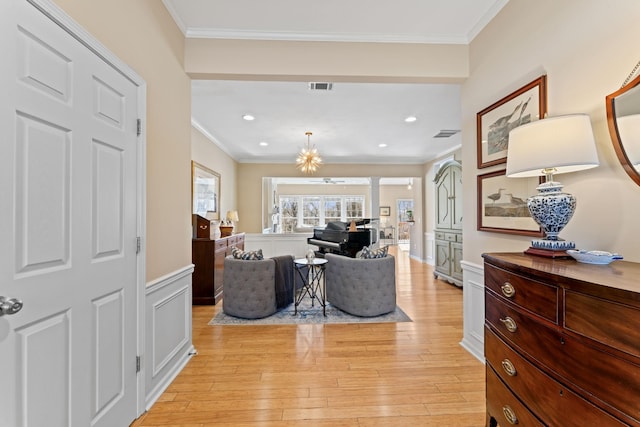 interior space featuring visible vents, light wood-type flooring, ornamental molding, decorative columns, and wainscoting