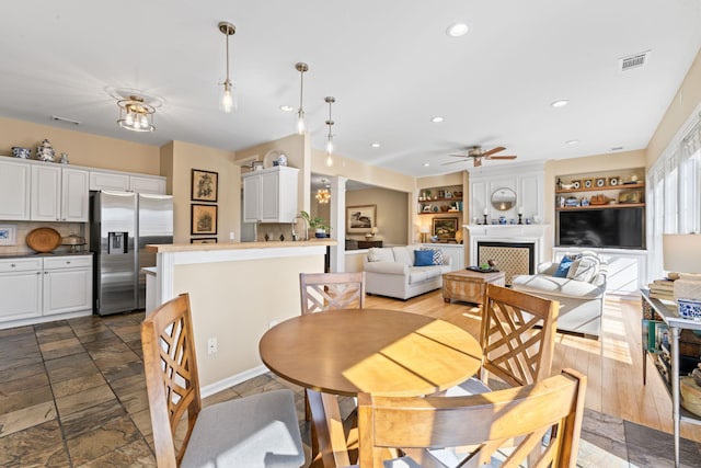 dining space with visible vents, recessed lighting, a large fireplace, and a ceiling fan