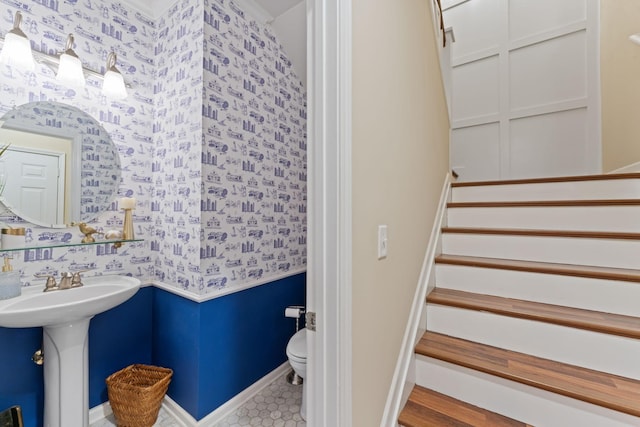 staircase featuring wallpapered walls and baseboards