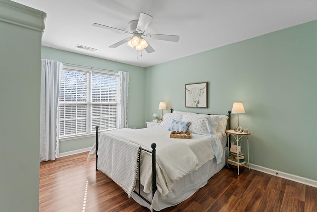 bedroom with visible vents, baseboards, wood finished floors, and a ceiling fan