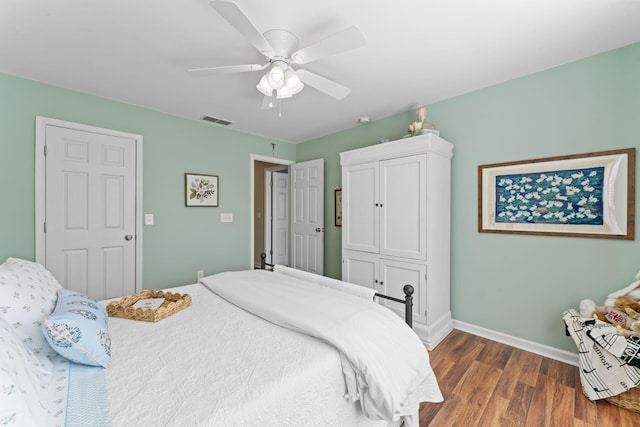 bedroom featuring visible vents, baseboards, wood finished floors, and a ceiling fan