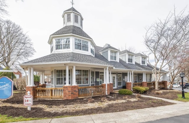 exterior space featuring a porch and a shingled roof