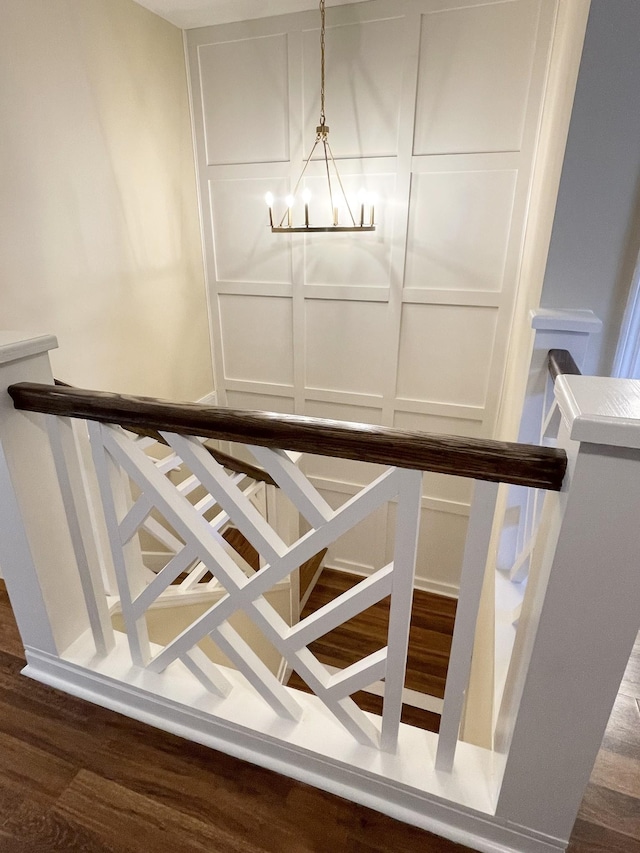 stairs with a decorative wall and a chandelier