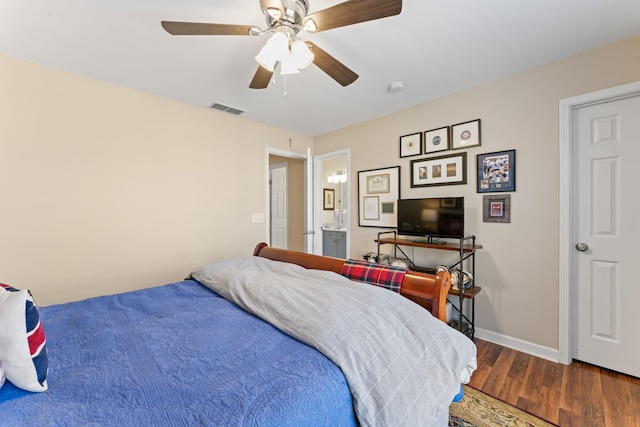 bedroom featuring visible vents, baseboards, ensuite bathroom, wood finished floors, and a ceiling fan