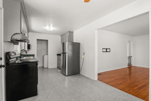 kitchen with baseboards, washer / clothes dryer, a sink, gray cabinetry, and stainless steel appliances