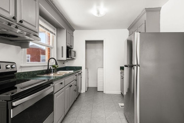 kitchen with under cabinet range hood, gray cabinets, appliances with stainless steel finishes, and a sink