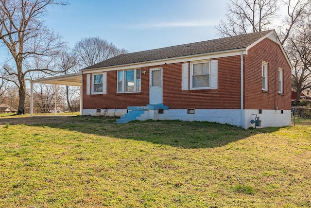 view of front of home with brick siding, an attached carport, a front yard, crawl space, and driveway