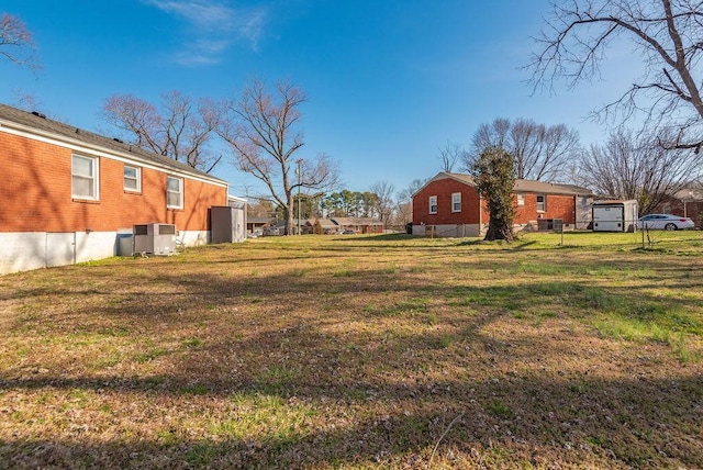 view of yard with central AC unit and fence