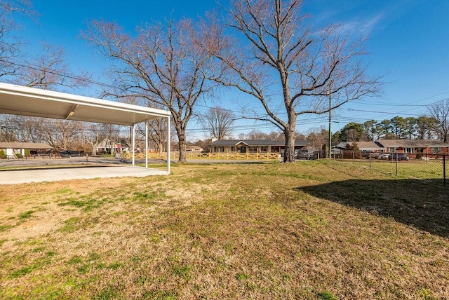 view of yard featuring driveway and fence