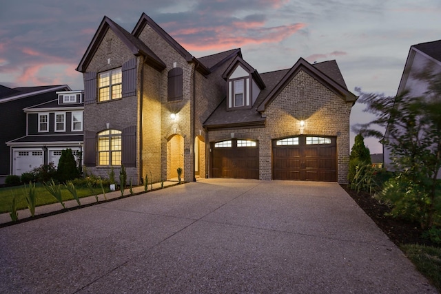 view of front of property featuring an attached garage, brick siding, and driveway