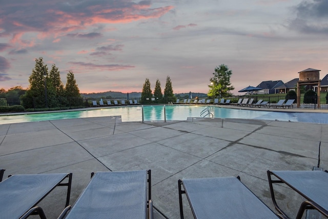 community pool with a patio and fence