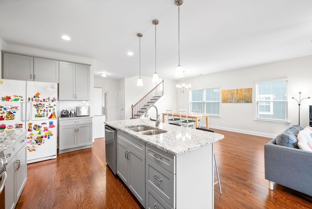 kitchen with gray cabinets, a sink, dark wood-style floors, open floor plan, and appliances with stainless steel finishes