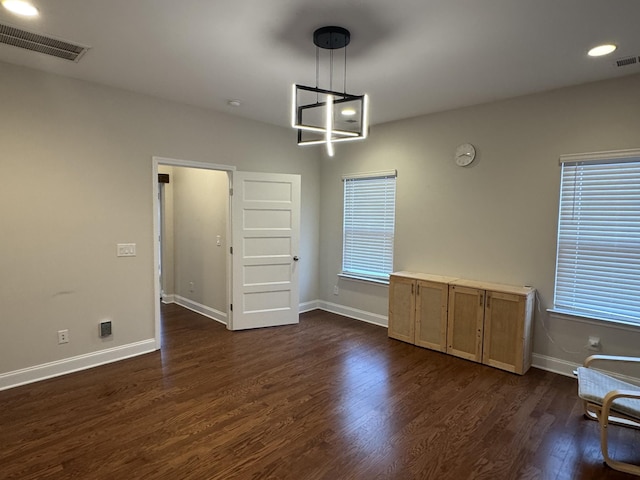 unfurnished dining area with visible vents, baseboards, plenty of natural light, and dark wood finished floors