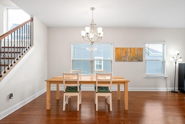 dining area featuring stairway, a notable chandelier, wood finished floors, and baseboards