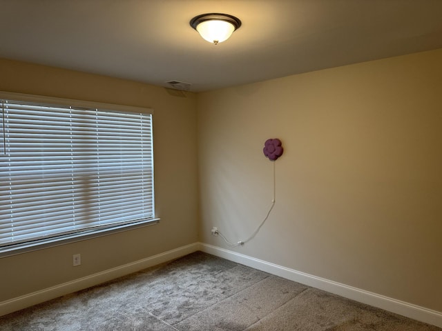 unfurnished room featuring visible vents, baseboards, and carpet