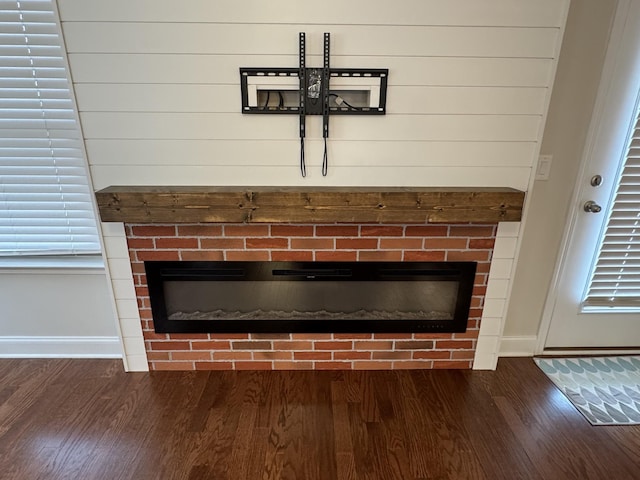 interior details featuring wood finished floors, a fireplace, and baseboards