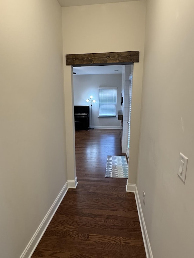 hall with baseboards and dark wood-type flooring