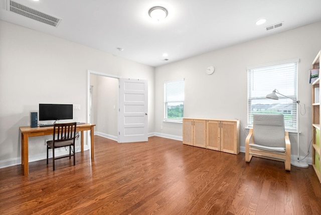 home office featuring wood finished floors, visible vents, and baseboards