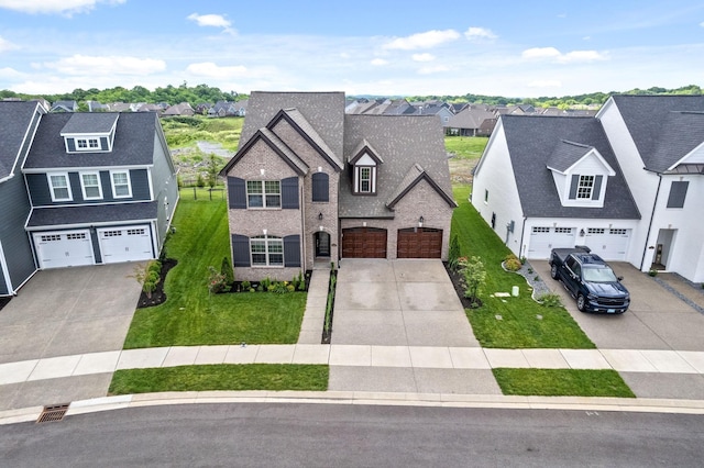 view of front facade featuring a front yard, brick siding, a garage, and driveway