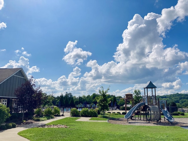 community play area with a yard and fence