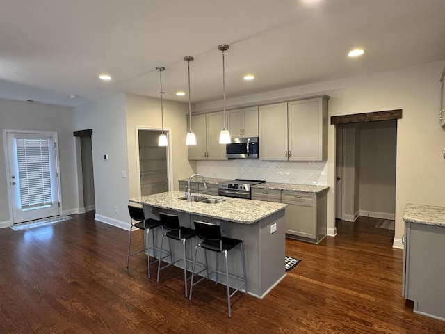 kitchen featuring gray cabinetry, dark wood-style flooring, appliances with stainless steel finishes, and a sink