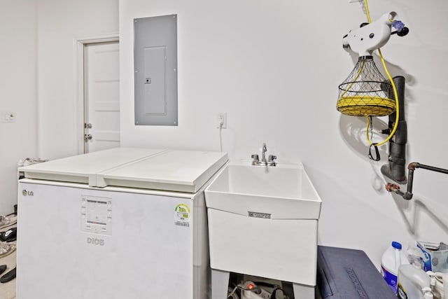 clothes washing area with electric panel and a sink