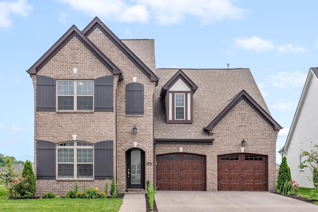 french country home featuring brick siding, board and batten siding, and concrete driveway