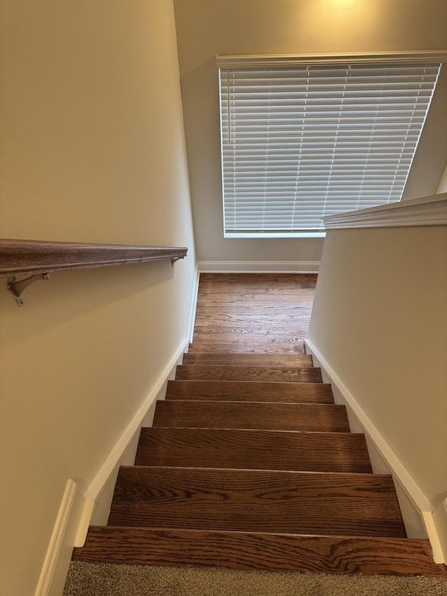 stairs with baseboards and wood finished floors