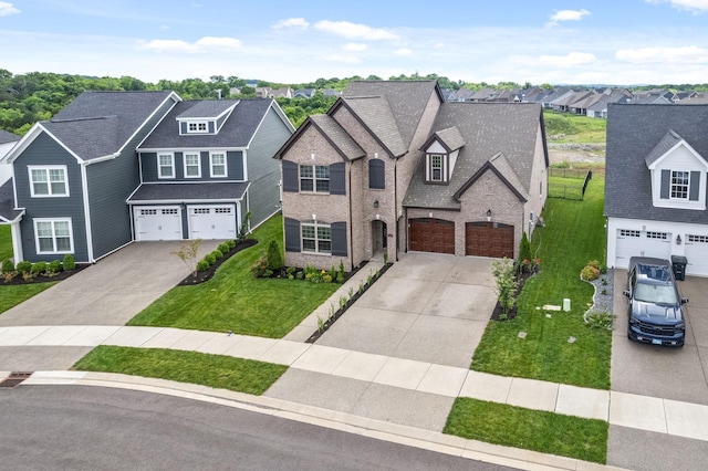 view of front facade with driveway, a residential view, a front yard, and an attached garage