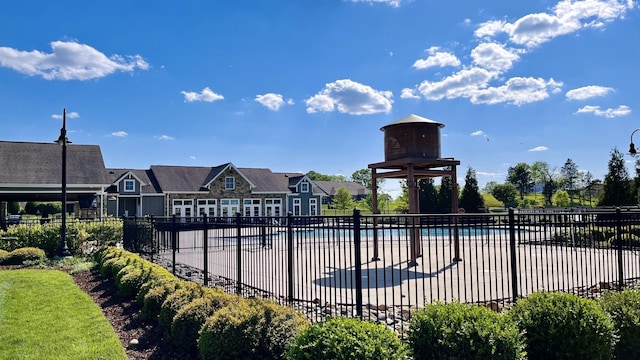 community pool with a patio area and fence