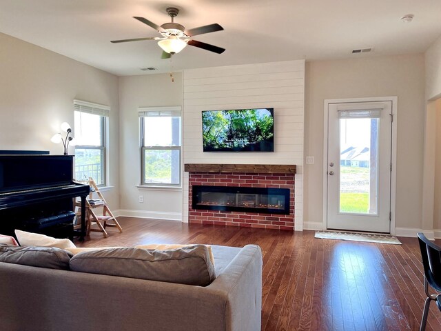 living area with visible vents, a fireplace, dark wood-type flooring, and baseboards