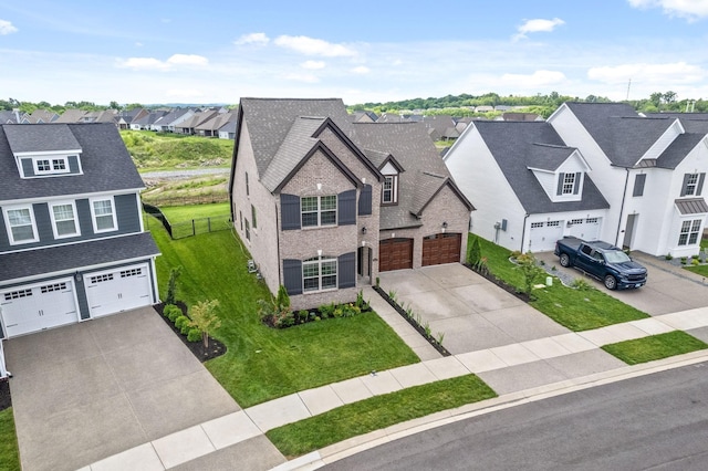 view of front of property with a front yard, driveway, a garage, and a residential view