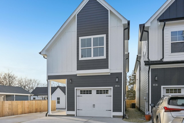 view of front of property featuring board and batten siding, an attached garage, and fence