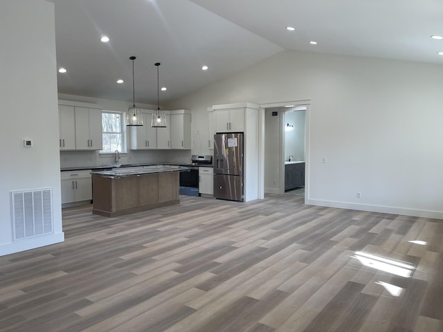 kitchen with stainless steel appliances, visible vents, light wood-style flooring, and a center island