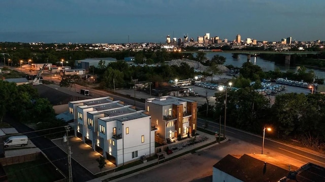 drone / aerial view with a view of city lights and a water view