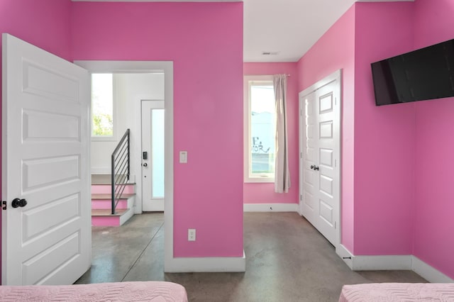 bedroom with visible vents, baseboards, and concrete flooring