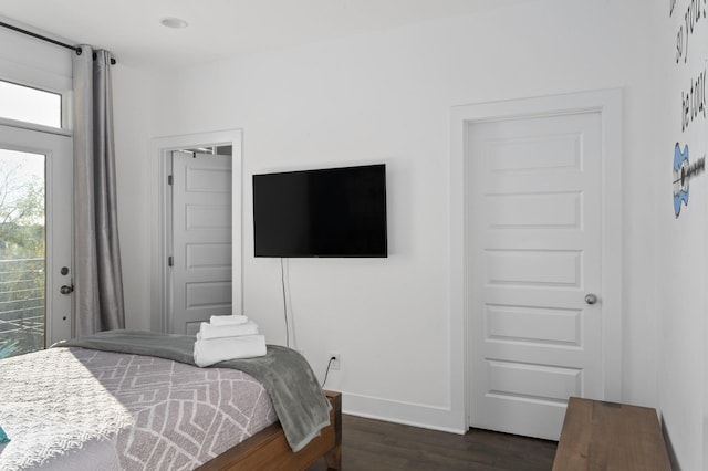 bedroom with baseboards, dark wood-style floors, and access to outside